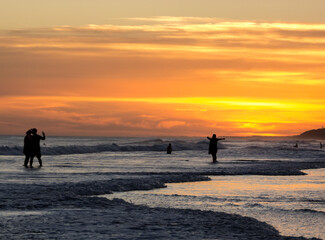 Fototapeta premium Silhouettes in the sunset at the beach