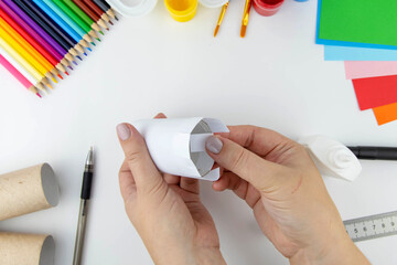 New year decoration. DIY and kids creativity concept. Step by step instructions: make a cow from a roll of toilet paper and paper. Step 5 bend inside the roll.