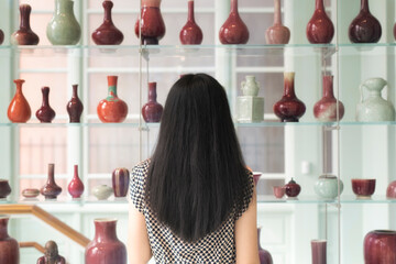 chinese woman looking at vases