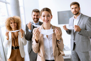 Portrait of young business people taking off their protective face masks