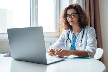 Hispanic latin female doctor make online video call consult patient on laptop. Medical assistant young woman therapist videoconferencing to web camera. Telemedicine concept. Online doctor appointment.