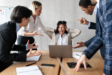 Unhappy Businesswoman Screaming While Coworkers Shouting At Her In Office