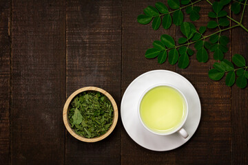 Moringa Tea on wooden background. Moringa oleifera tropical herb healthy lifestyle concept.