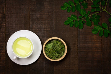 Moringa Tea on wooden background. Moringa oleifera tropical herb healthy lifestyle concept.