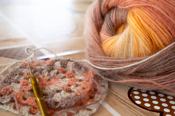 Close-up, grey and multi colored yarns and crochet needle. 