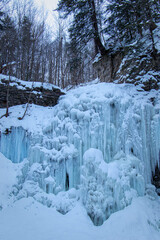 winter in the forest and frozen waterfall
