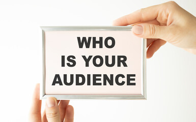 Businesswoman showing card with WHO IS YOUR AUDIENCE message