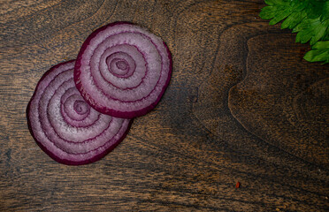 Fototapeta na wymiar Onion slices on a wooden cutting board. Top view.