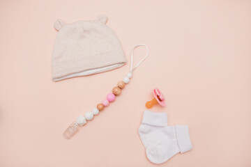 Clothes for a newborn girl: a tiny pink hat, cotton pants on a light background. baby clothes on the table. Children's fashion. clothes for newborns for girls. modern kids clothing store top view