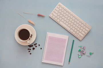 On a light background, a cup of coffee, a notepad, a phone, a keyboard. Workplace in the office....