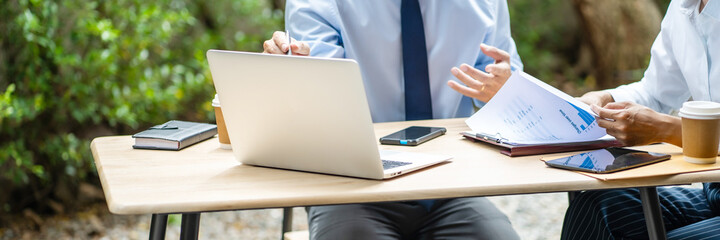 Team executives sitting at outdoor workplace discussing business model.