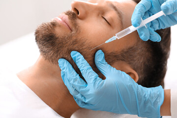 Closeup of bearded man getting beauty injection at clinic