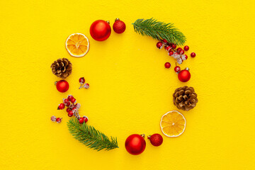 Spruce branch, cones and vintage toys decoration on christmas or new year on yellow background