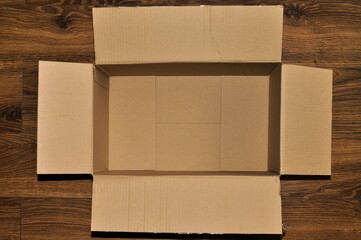 Rectangular cardboard box on wooden floor 