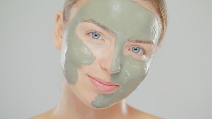 Close-up Beauty Portrait Of Young Caucasian Blonde Woman She Have Green Mask On Face And Smiling On Gray Background Skin Care Cosmetic Concept