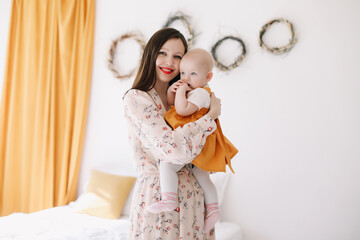 Loving mother hold in arms little baby girl. Mom and daughter enjoy tender family moment at home. childcare, maternity concept