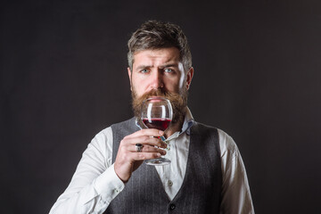 Wine glass. Tasting alcohol. Red wine. Man with alcohol. Bearded man with glass of wine. Man drinks red wine. Man with Bordeaux.