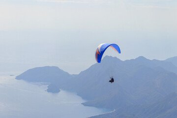 Paragliders flying from a top of Tahtali mountain near Kemer, Antalya Province in Turkey. Concept of active lifestyle and extreme sport adventure