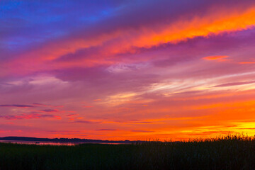 Beautiful colorful sunset over the lake summer landscape.