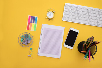 school supplies on a yellow background. distance learning. School notebook and office supplies on a yellow table. abstract background. Education during the Covid 19 pandemic. Flat lay.