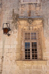 Old, vintage yellow brick wall with window and lamp. 