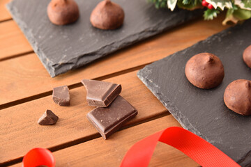 Chocolate truffles on slate plate on wooden table elevated view