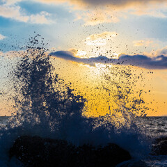 Beautiful shoreline scene with waves at sunset beams