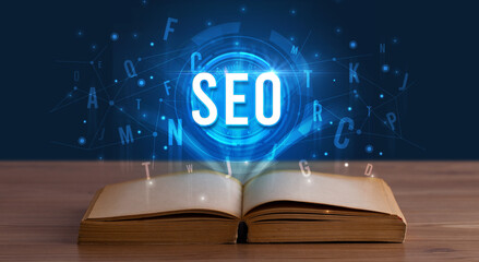 SEO inscription coming out from an open book, digital technology concept