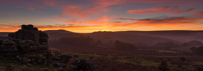 A panorama of Hound tor on Dartmoor with a spectacular sunset