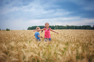 Naklejka na ściany i meble Kids running in wheat field, live life to the fullest, freedom, childhood and happiness