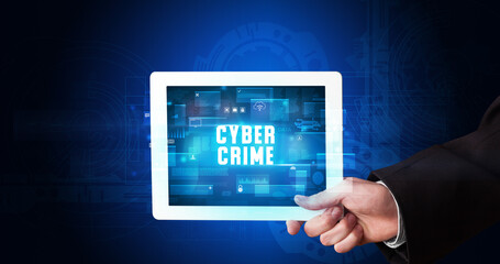 Young business person working on tablet and shows the digital sign: CYBER CRIME