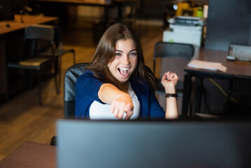 Joyful woman at her desk in the office