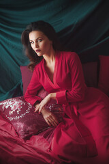 Fototapeta premium Portrait of beautiful young woman with makeup in red dress. Fashion photo