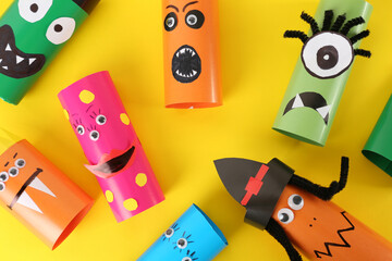 Funny monsters on yellow background, flat lay. Halloween decoration