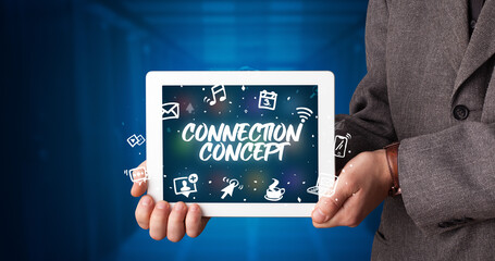 Young business person working on tablet and shows the inscription: CONNECTION CONCEPT