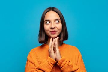 hispanic woman feeling proud, mischievous and arrogant while scheming an evil plan or thinking of a...