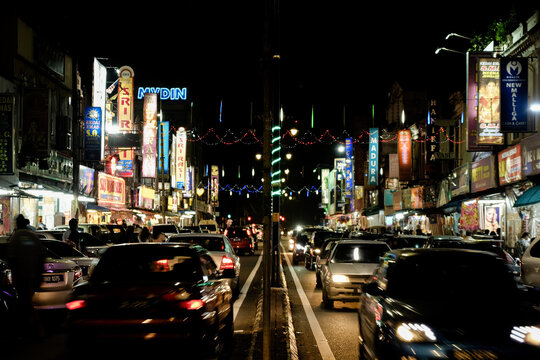 "Klang,Malaysia- Circa November, 2020: Long exposure, motion blur and noise effect picture of moving car in busy Little India Street in Klang during night time."
