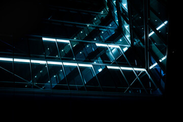 Looking up at glass office building at night.