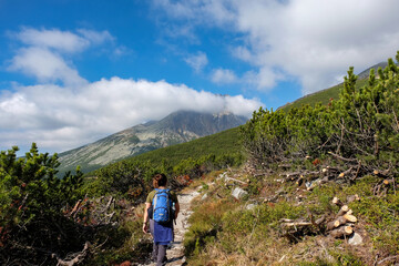 Fototapeta premium Hikers on trail at Great Cold Valley, Vysoke Tatry (High Tatras), Slovakia. The Great Cold Valley is 7 km long valley, very attractive for tourists