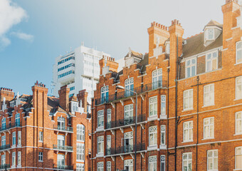 Fototapeta na wymiar Paisaje urbano con vistas a un conjunto de edificios y un rascacielos blanco de fondo durante un día soleado en Londres