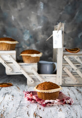 Fresh muffins on a wooden table. The inscription on the badge 