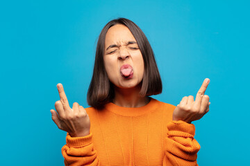 hispanic woman feeling provocative, aggressive and obscene, flipping the middle finger, with a...