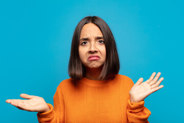 hispanic woman feeling puzzled and confused, unsure about the correct answer or decision, trying to...