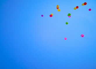 Multicolored balloons flying high in the blue sky