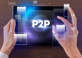 Close-up of a hand holding tablet with P2P abbreviation, modern technology concept