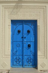  Traditional wooden blue aged Tunisian door with ornament. Sidi Bou Said, Carthage, Tunisia. 06/13/2019.
