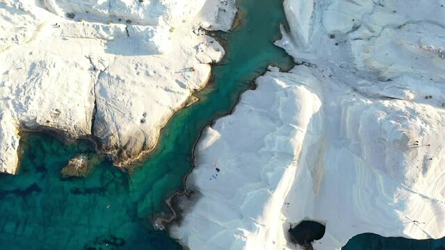 Cinematic aerial drone footage of white rocks and turquoise water on Sarakiniko Beach, Milos Island, Greece
