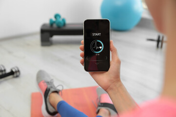 Young woman using fitness app on smartphone indoors, closeup - obrazy, fototapety, plakaty