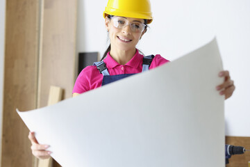 Woman architect holds white Whatman paper in her hands. Design and construction of buildings and...
