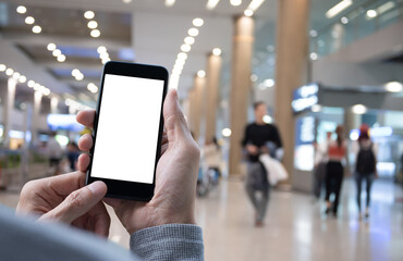 Mock up image of man hand using blank screen mobile phone with people shopping in department store